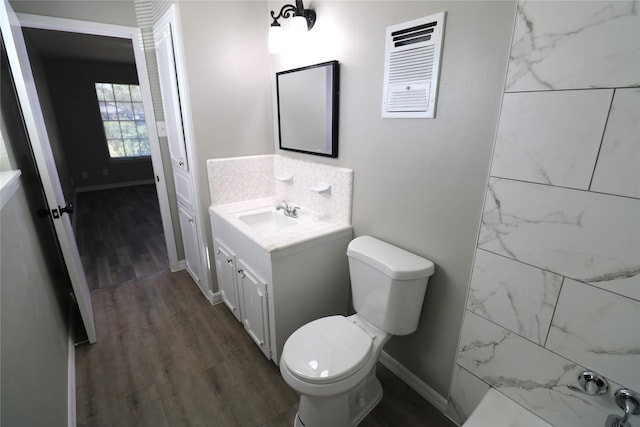 bathroom with hardwood / wood-style flooring, toilet, and vanity