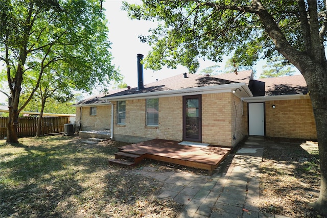 back of property with a lawn, central AC unit, and a wooden deck