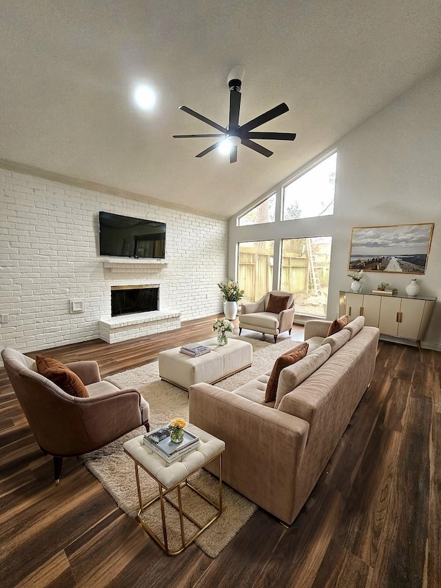 living room featuring brick wall, dark hardwood / wood-style flooring, a fireplace, high vaulted ceiling, and ceiling fan