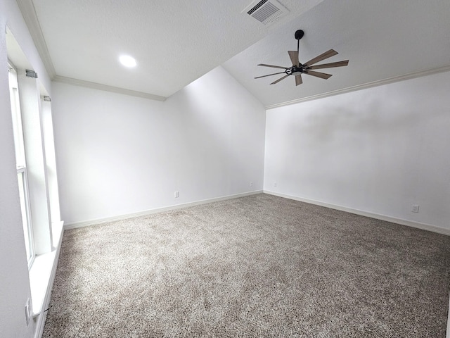 spare room with a textured ceiling, lofted ceiling, carpet floors, ceiling fan, and crown molding