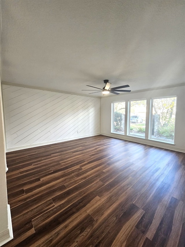 unfurnished room with dark wood-type flooring and ceiling fan