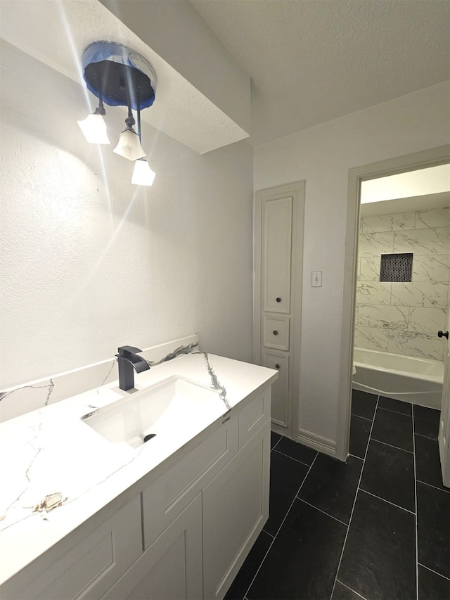 bathroom with vanity, tile patterned flooring, a textured ceiling, and tiled shower / bath