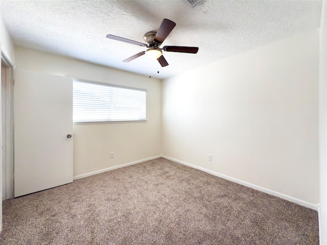 spare room featuring a textured ceiling, ceiling fan, and carpet