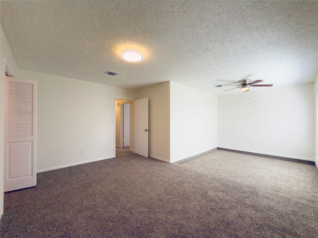 carpeted spare room featuring a textured ceiling and ceiling fan