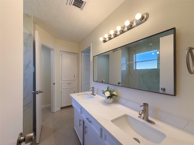 bathroom with a textured ceiling and vanity