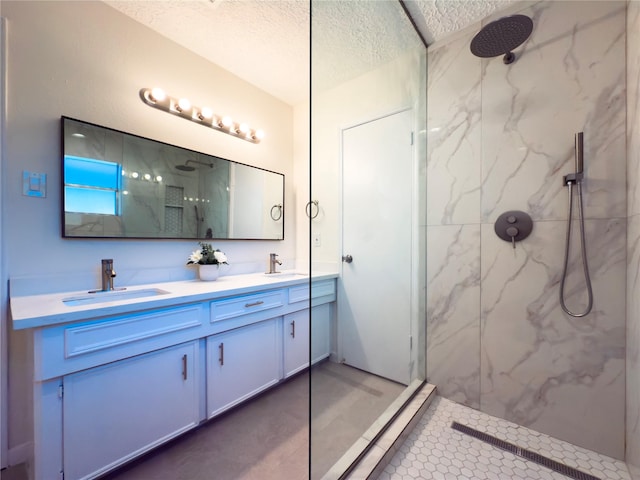 bathroom featuring vanity, a textured ceiling, and a tile shower