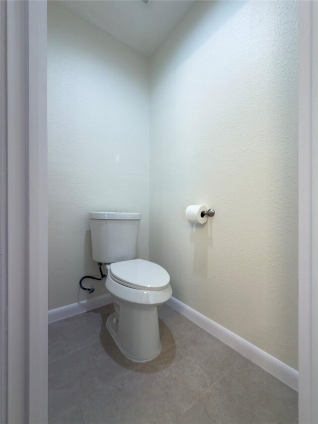 bathroom with toilet and tile patterned flooring