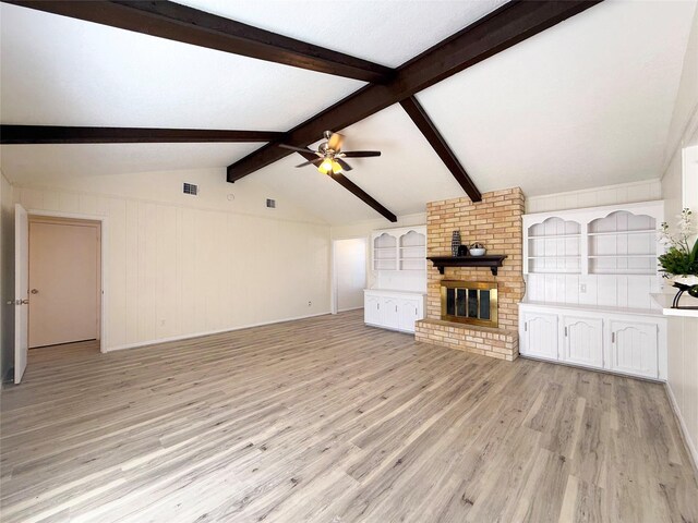 unfurnished living room with ceiling fan, vaulted ceiling with beams, light hardwood / wood-style flooring, and a brick fireplace