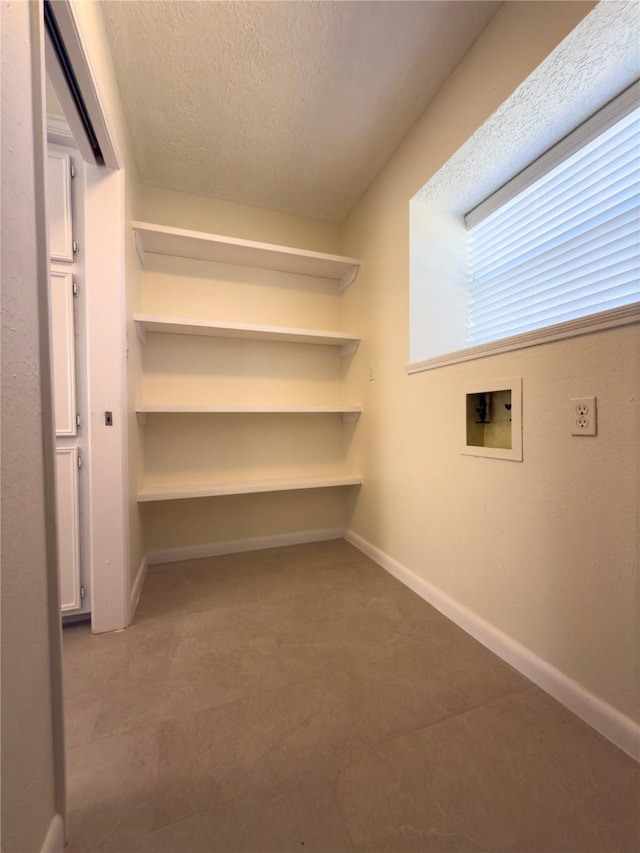 laundry room with hookup for a washing machine and a textured ceiling