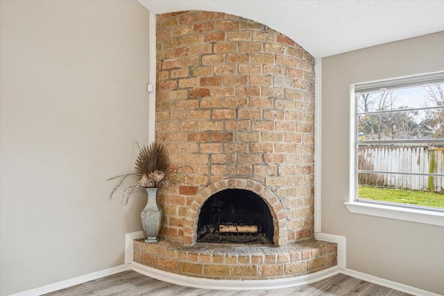 room details featuring a brick fireplace and hardwood / wood-style floors