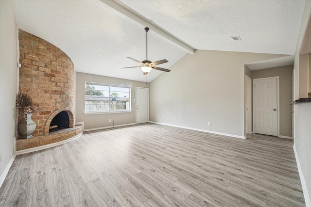 unfurnished living room with a textured ceiling, a fireplace, light hardwood / wood-style flooring, and lofted ceiling with beams