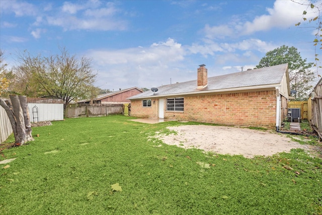 back of house with a lawn and a patio