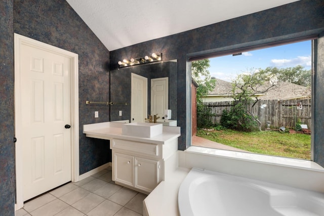 bathroom featuring vanity, vaulted ceiling, tile patterned floors, a bathing tub, and a textured ceiling