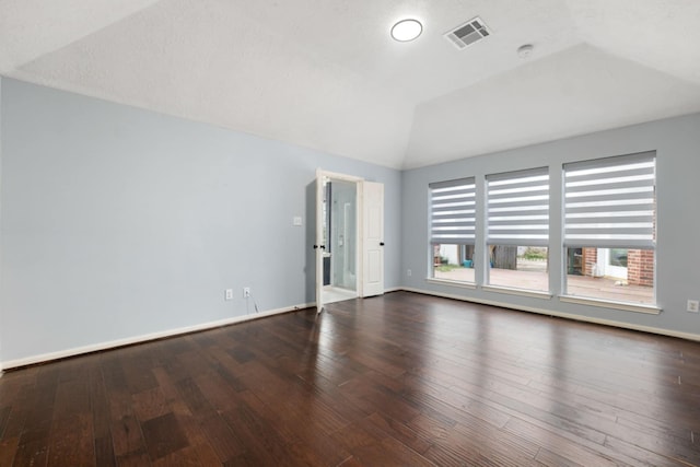 unfurnished room featuring vaulted ceiling and dark hardwood / wood-style flooring