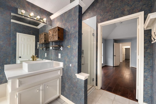 bathroom with a shower with shower door, tile patterned floors, vanity, and ornamental molding