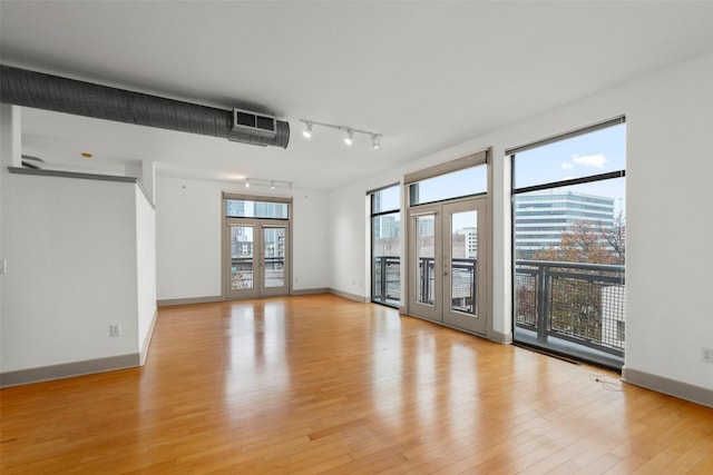 empty room with light hardwood / wood-style floors and french doors