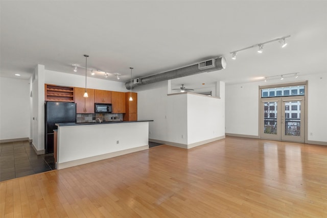 kitchen with light hardwood / wood-style floors, ceiling fan, tasteful backsplash, decorative light fixtures, and black appliances