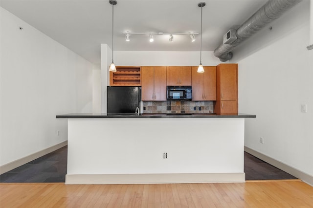 kitchen with black appliances, dark hardwood / wood-style floors, hanging light fixtures, and tasteful backsplash