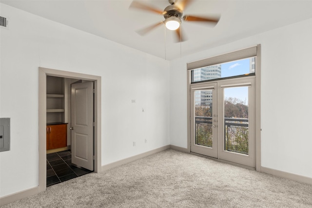 unfurnished room with ceiling fan, dark carpet, and french doors