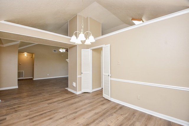 unfurnished dining area featuring an inviting chandelier, hardwood / wood-style flooring, and high vaulted ceiling