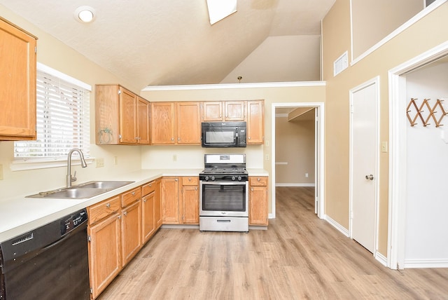 kitchen featuring sink, light wood-type flooring, black appliances, and vaulted ceiling