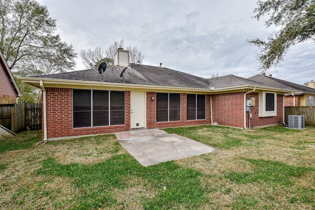 back of property with a patio, a lawn, and central AC