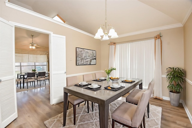 dining room with hardwood / wood-style floors, a chandelier, lofted ceiling, and ornamental molding