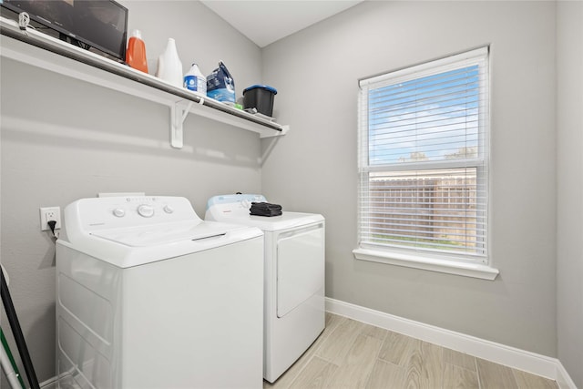 washroom featuring washer and clothes dryer, a wealth of natural light, and light hardwood / wood-style flooring