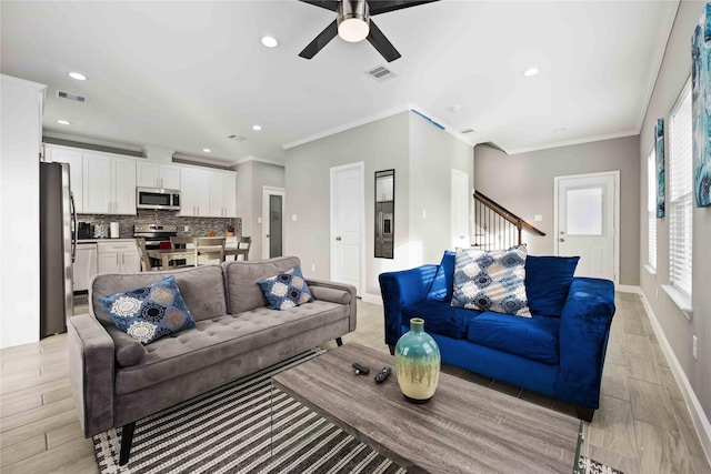 living room with ceiling fan and ornamental molding