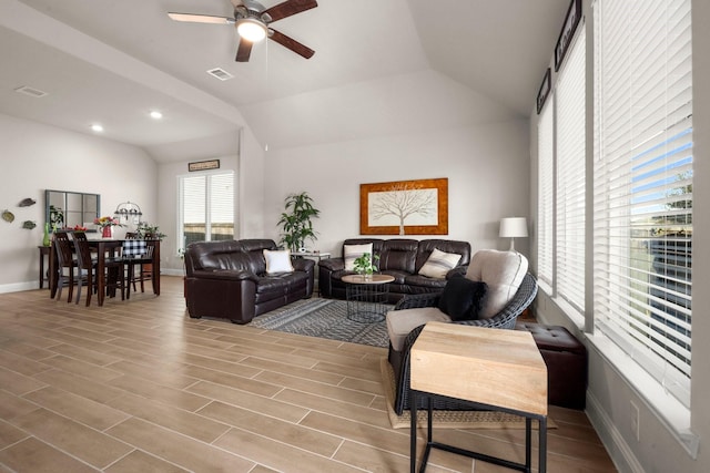 living room featuring ceiling fan, light hardwood / wood-style floors, and lofted ceiling