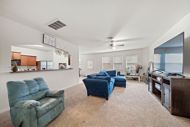 living room featuring ceiling fan and light colored carpet