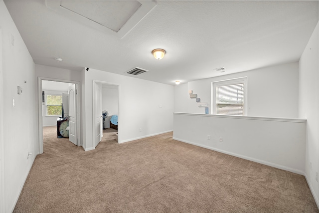 spare room featuring light colored carpet