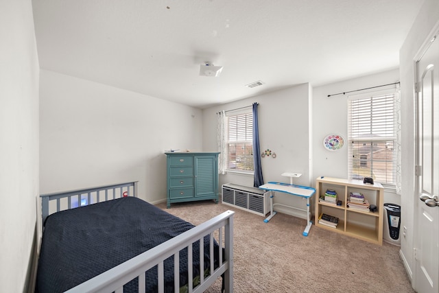 bedroom with light carpet and multiple windows