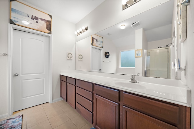 bathroom with lofted ceiling, tile patterned floors, vanity, and a shower with shower door