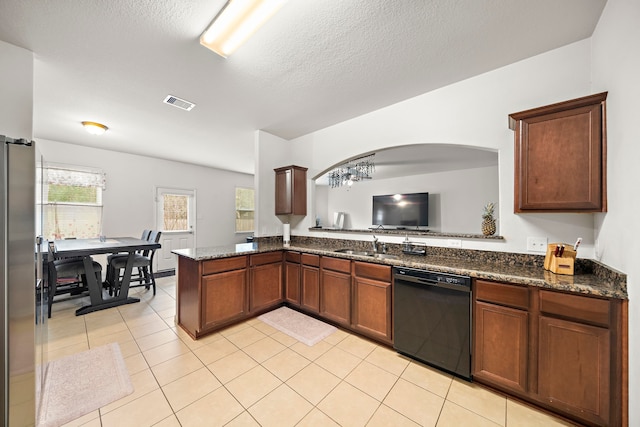 kitchen with stainless steel fridge, dishwasher, kitchen peninsula, and dark stone countertops