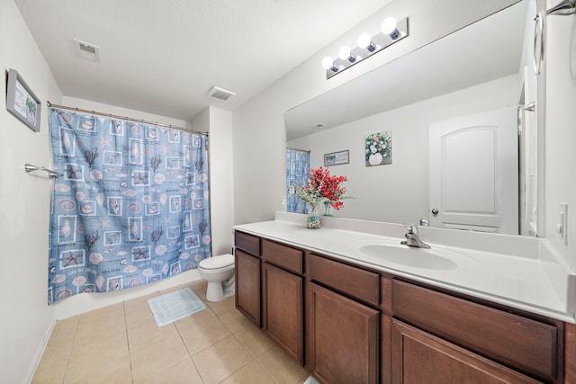 bathroom featuring toilet, vanity, tile patterned floors, and curtained shower