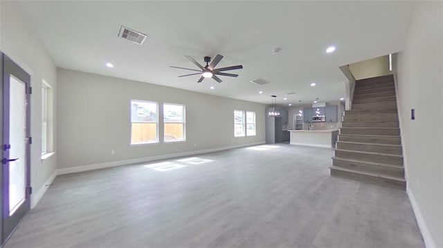 unfurnished living room featuring ceiling fan and light wood-type flooring