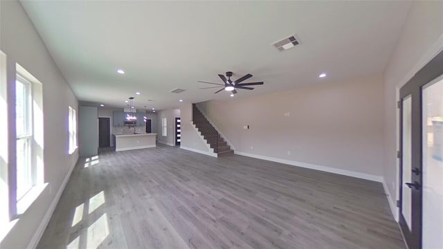 unfurnished living room with ceiling fan and wood-type flooring