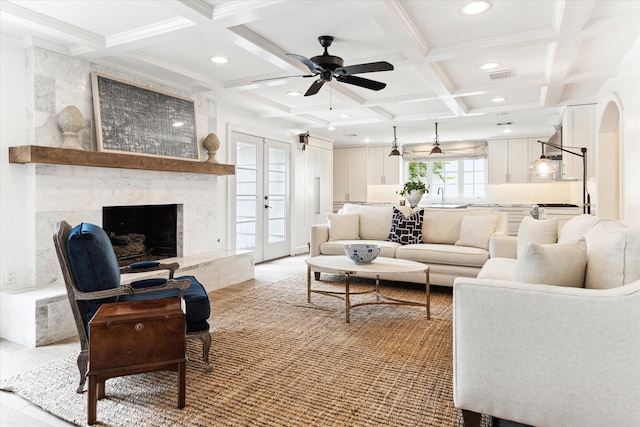 living room with french doors, sink, ceiling fan, beam ceiling, and coffered ceiling