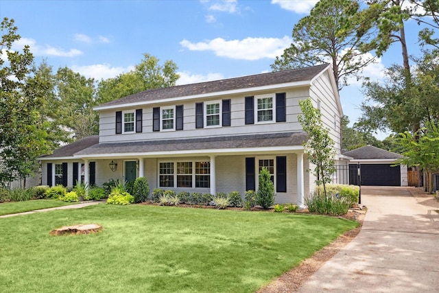 view of front of house with a garage, a front lawn, a porch, and an outbuilding