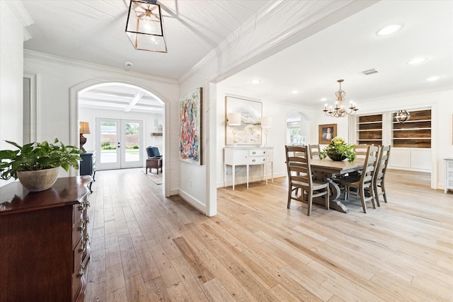 dining space with a notable chandelier, beamed ceiling, coffered ceiling, ornamental molding, and french doors