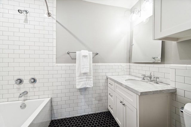 full bathroom featuring toilet, tile walls, vanity, and tiled shower / bath combo