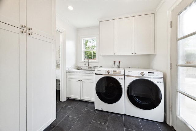 clothes washing area with cabinets, ornamental molding, washer and clothes dryer, and sink