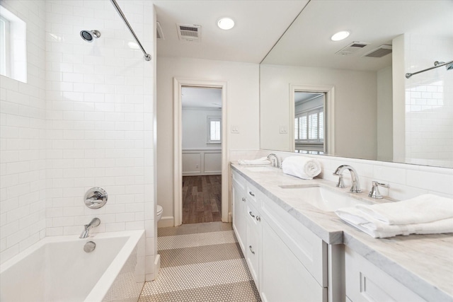 full bathroom featuring toilet, tile patterned flooring, tiled shower / bath, and vanity