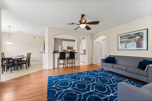 tiled living room featuring ceiling fan