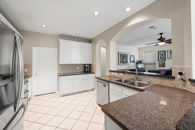 kitchen featuring ceiling fan, appliances with stainless steel finishes, tasteful backsplash, white cabinets, and sink