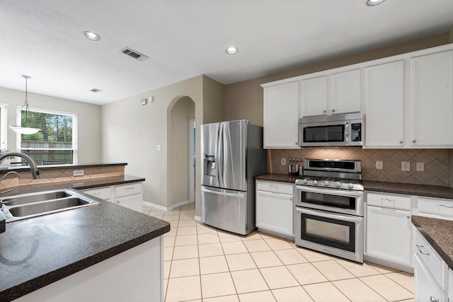 kitchen with white cabinetry, stainless steel appliances, decorative backsplash, hanging light fixtures, and sink