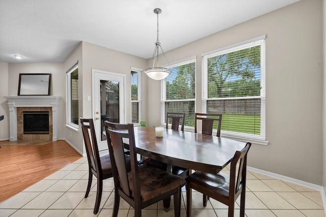 dining area featuring light tile patterned floors and a fireplace