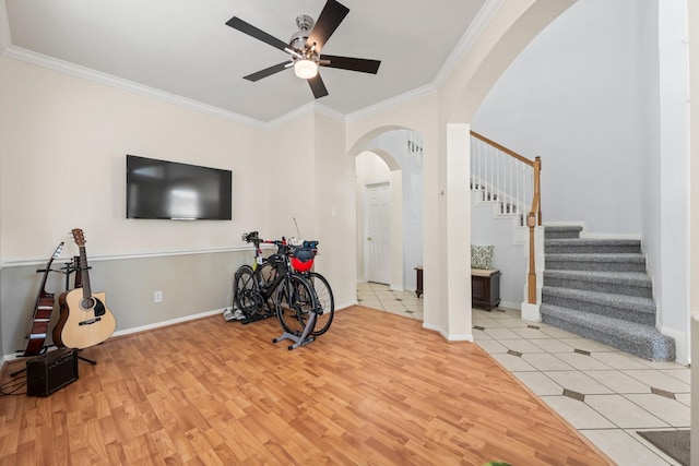 workout room with ceiling fan, light tile patterned floors, and crown molding