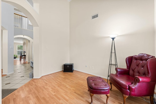 living area with wood-type flooring and a high ceiling